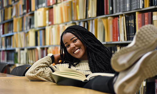 MSU student in the library with a bright smile