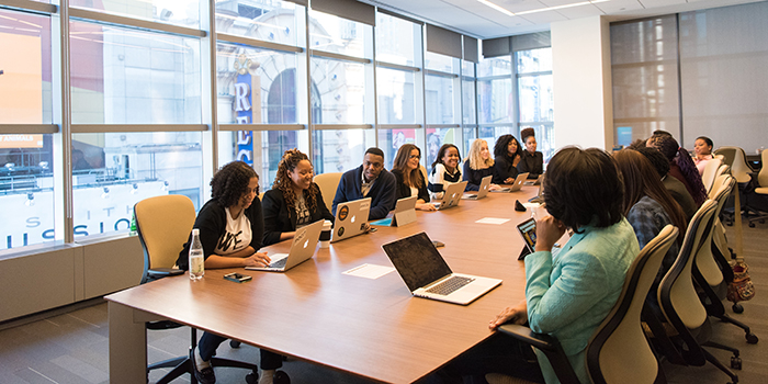 group of people talking together at a large meeting room table